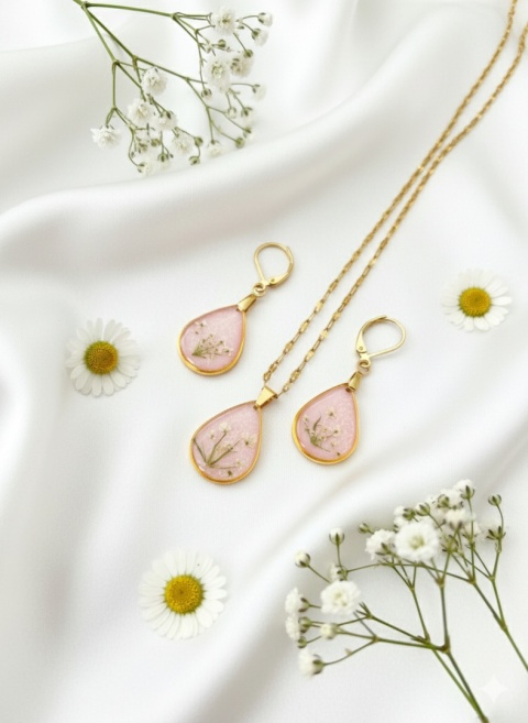 komplet biżuterii z kwiatami na satynowej tkaninie