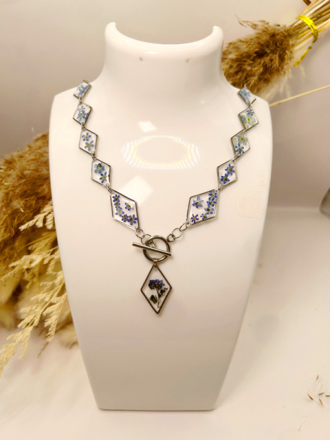 Biżuteria z zatopionymi kwiatami – elegancki naszyjnik w kształcie rombów z niezapominajkami. Biżuteria z zatopionymi kwiatami – elegancki naszyjnik w kształcie rombów z niezapominajkami.