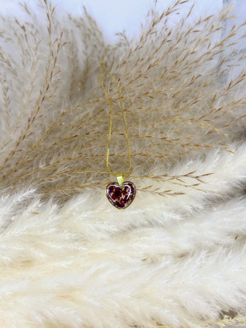 Naszyjnik handmade z żywicy w kształcie serca, z pokruszonymi płatkami róży i delikatnymi złotymi akcentami, na pozłacanym łańcuszku.