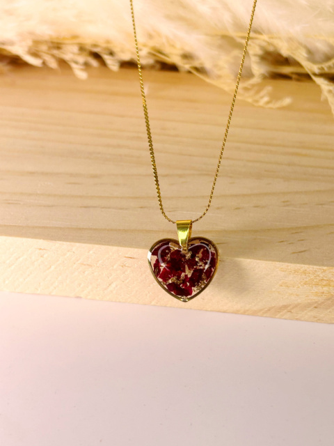 Naszyjnik handmade z żywicy w kształcie serca, z pokruszonymi płatkami róży i delikatnymi złotymi akcentami, na pozłacanym łańcuszku.