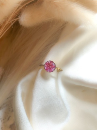 Pierścionek z różowym kwiatem zatopionym w żywicy