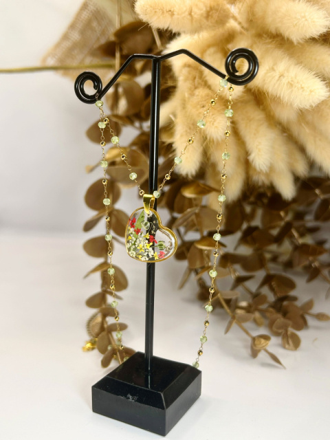 Biżuteria handmade – naszyjnik z zawieszką-sercem z żywicy i kolorowymi kwiatami, zawieszony na delikatnym łańcuszku z zielonymi kamieniami. Biżuteria handmade – naszyjnik z zawieszką-sercem z żywicy i kolorowymi kwiatami, zawieszony na delikatnym łańcuszku z zielonymi kamieniami.