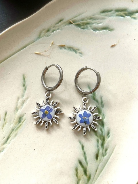 Delikatne posrebrzane kolczyki z kwiatami niezapominajek zatopionymi w żywicy.