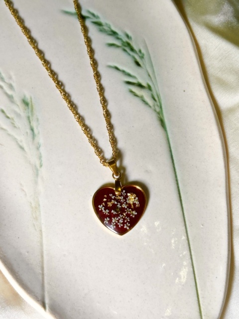 Naszyjnik z żywicy w kształcie serduszka z kolorowymi kwiatami na bordowym tle, złota folia, łańcuszek typu singapurka.
