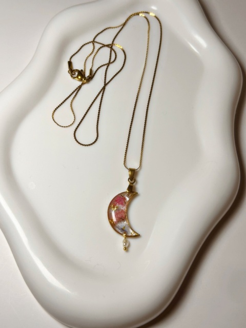 naszyjnik w kształcie półksiężyca na białej tacy