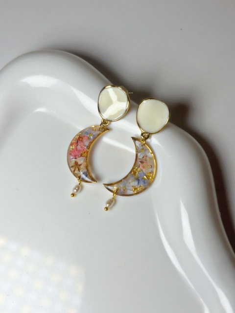 kolczyki w kształcie półksiężyca na białej tacy